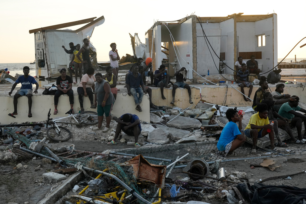 FILE - People gather among debris near a bridge in Black River, Jamaica, Oct. 30, 2025, in the aftermath of Hurricane Melissa. (AP Photo/Matias Delacroix, File)