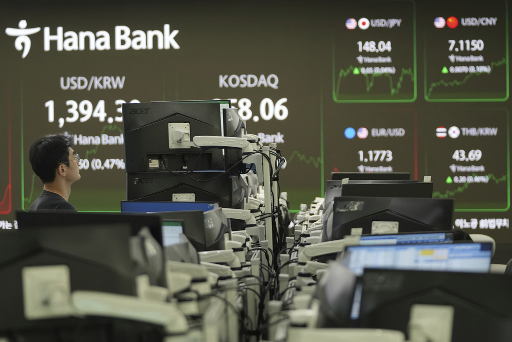 A dealer watches computer monitors near the screens showing the foreign exchange rates at a dealing room of Hana Bank in Seoul, South Korea, Friday, Sept. 19, 2025. (AP Photo/Lee Jin-man)