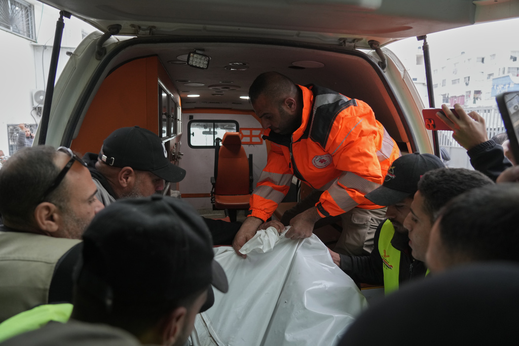 People carry a bag containing the bodies of the Palestinian journalists Abd Shaat and Mohamed Qeshta, who were killed in an Israeli strike on a vehicle, before their funeral at Shifa Hospital, in Gaza City, Wednesday, Jan. 21, 2026. (AP Photo/Jehad Alshrafi)