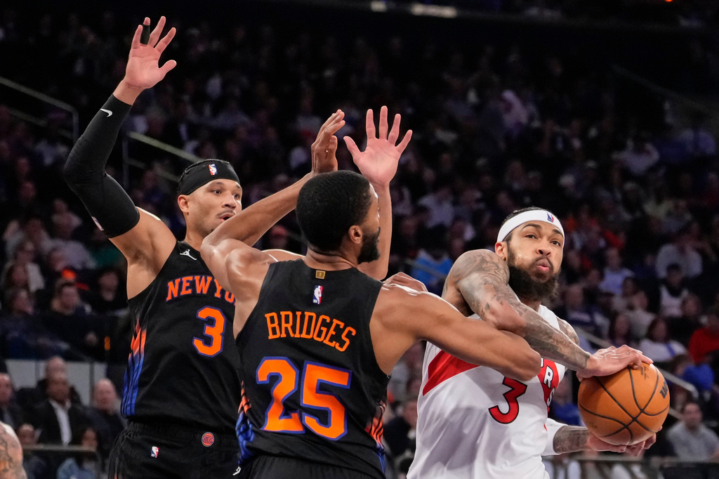 Toronto Raptors forward Brandon Ingram (3) drives past New York Knicks guard Mikal Bridges (25) and New York Knicks guard Josh Hart (3) during the first half of an NBA basketball game, Friday, April 10, 2026, in New York. (AP Photo/Yuki Iwamura)