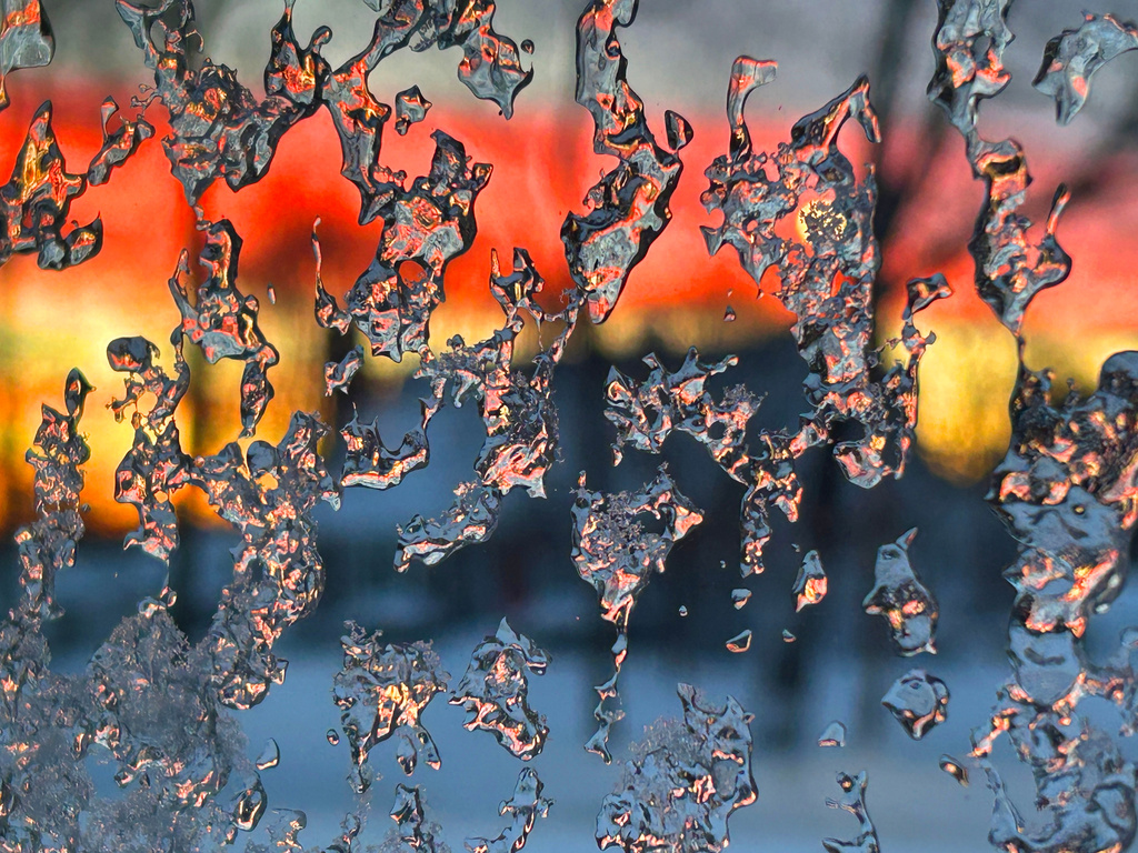 Ice crystals form on a window pane as the sun rises, Tuesday, Feb. 24, 2026, in North Attleborough Mass., one day after a blizzard dumped between two and three feet of snow. AP Photo/Mark Stockwell)