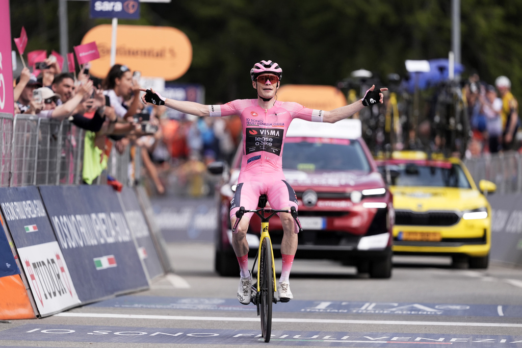 Denmark's Jonas Vingegaard wears the pink jersey of the race overall leader, celebrates winning the 16th stage of the Giro d'Italia cycling race from Bellinzona to Cari', Switzerland, Tuesday May 26, 2026. (Massimo Paolone/LaPresse via AP)