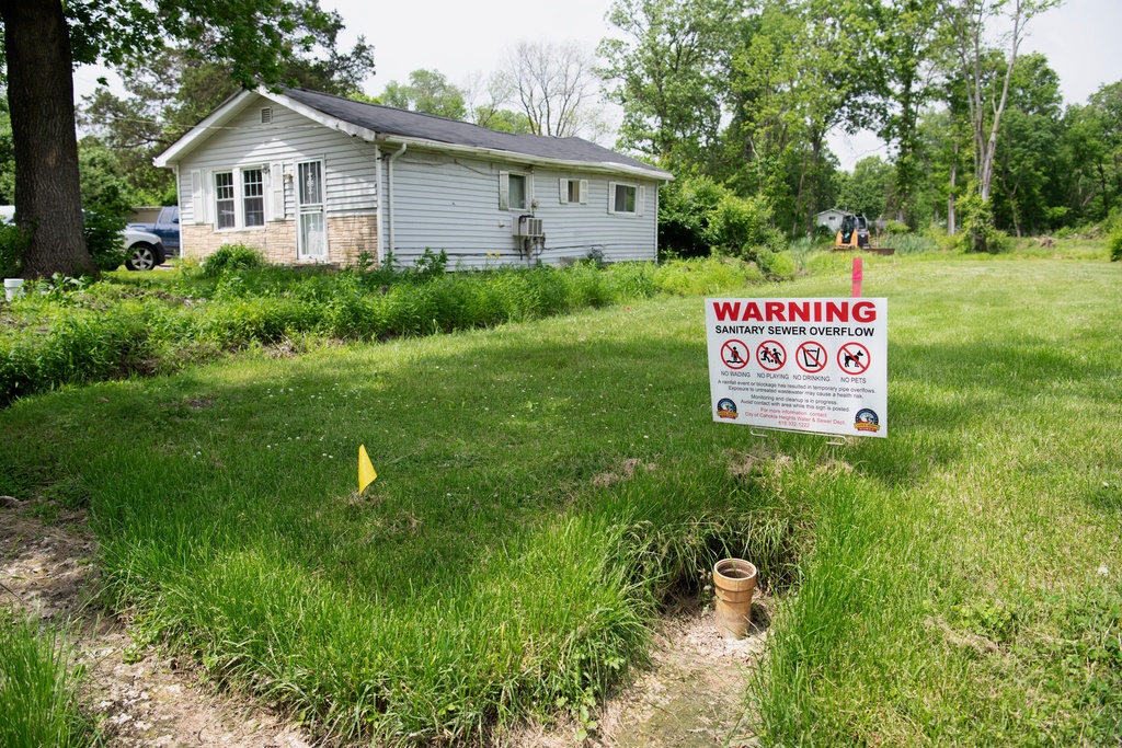 A sign warns of the dangers of sewer overflows in flood-prone Cahokia Heights, Ill., May 15, 2025. (AP Photo/Michael Phillis)