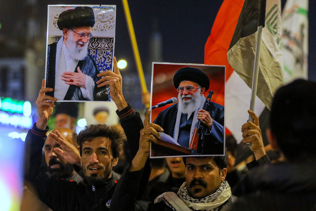 Iraqi Shiites hold pictures of Iranian Supreme Leader Ayatollah Ali Khamenei, who was killed by a U.S. airstrike in Tehran, during a symbolic funeral, in Najaf, Iraq, Sunday, March 1, 2026. (AP Photo/Anmar Khalil)