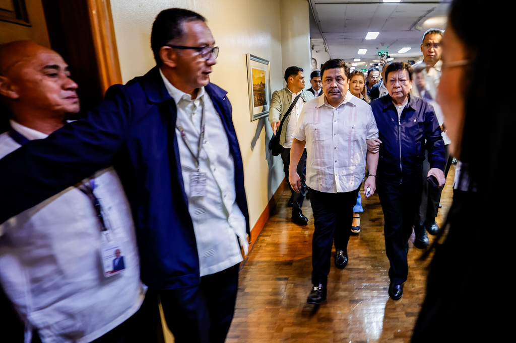 Philippines Sen. Jinggoy Estrada, center, walks through the hallway to announce his surrender at the Senate of the Philippines in Pasay City, Philippines Monday, June 1, 2026, after the Sandiganbayan graft court issued a warrant of arrest in connection with the plunder and corruption case files against him. (AP Photo/Gerard Carreon)