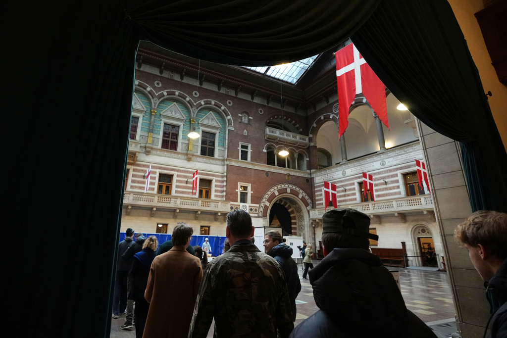 People line up to receive their ballots at a polling station at City Hall in Copenhagen, Denmark, on Tuesday, March 24, 2026, during the general election. (AP Photo/Sergei Grits)