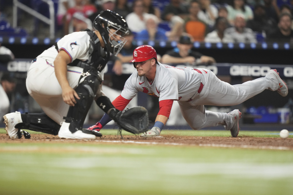 St. Louis Cardinals' Nolan Gorman, right, beats the throw to score on a single by Pedro Pages during the eighth inning of a baseball game against the Miami Marlins, Monday, Aug. 18, 2025, in Miami. (AP Photo/Lynne Sladky)
