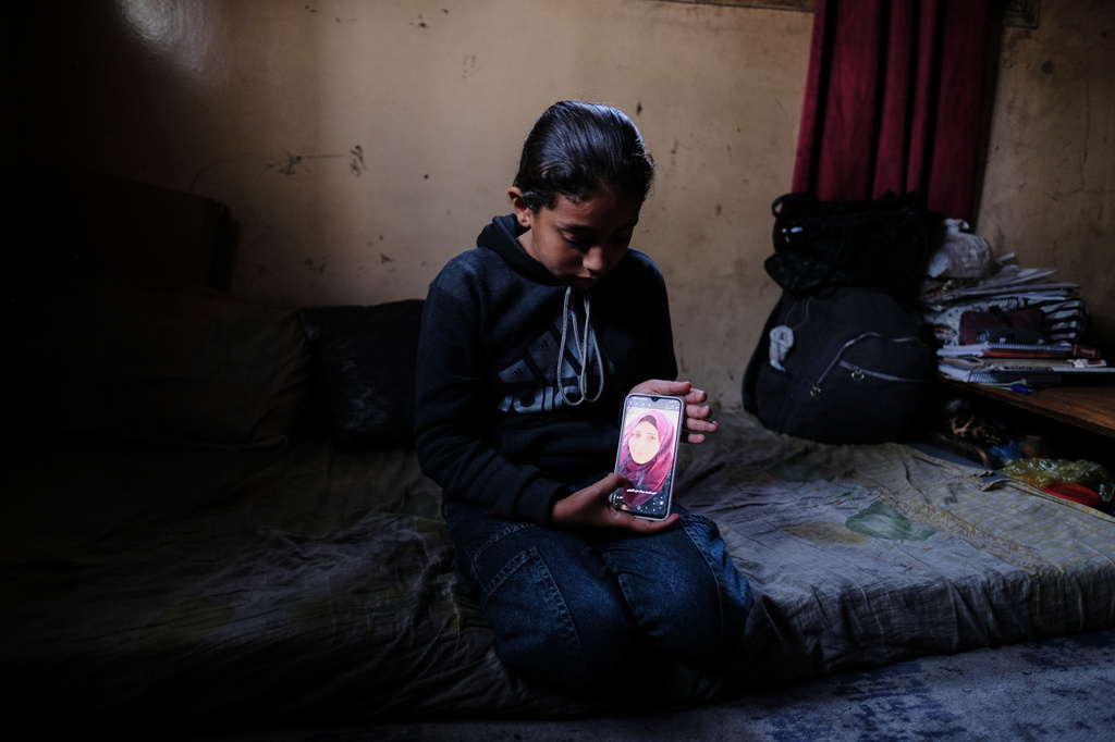 Eleven-year-old Ghazal al-Kibritti, who lost her parents and three siblings in an Israeli airstrike, poses with a photo of her mother, Sana, at her grandparents' home in Gaza City, Sunday, April 26, 2026. (AP Photo/Jehad Alshrafi)