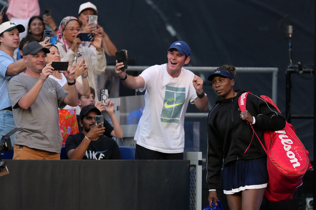 Spectators takes photos of Venus Williams of the U.S. as she walks onto court for her first round match against Olga Danilovic of Serbia at the Australian Open tennis championship in Melbourne, Australia, Sunday, Jan. 18, 2026. (AP Photo/Aaron Favila)