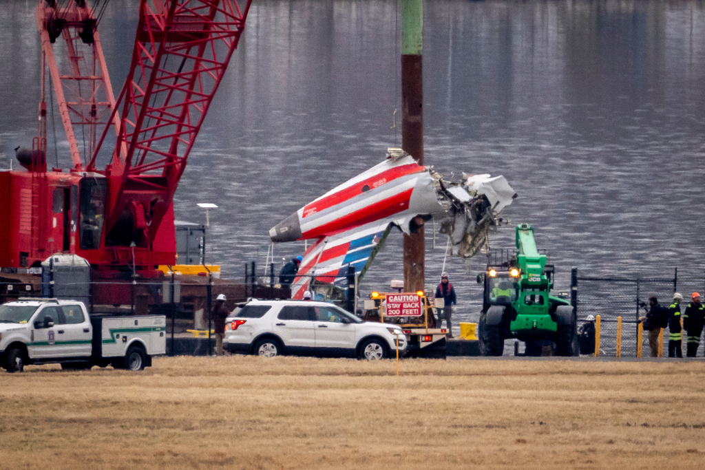 FILE - A crane offloads a piece of wreckage from a salvage vessel onto a flatbed truck, near the wreckage site in the Potomac River of a mid-air collision between an American Airlines jet and a Black Hawk helicopter, at Ronald Reagan Washington National Airport, Feb. 5, 2025, in Arlington, Va. (AP Photo/Ben Curtis, File)