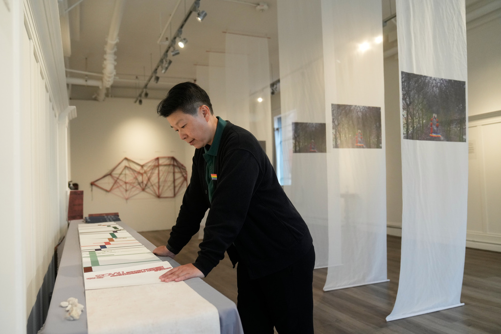 OUT Museum founder Xiangqi Chen looks at "Tracing: Queering Chinese Historical Archive" displayed at the Chinatown museum Monday, June 22, 2026, in San Francisco. (AP Photo/Jeff Chiu)