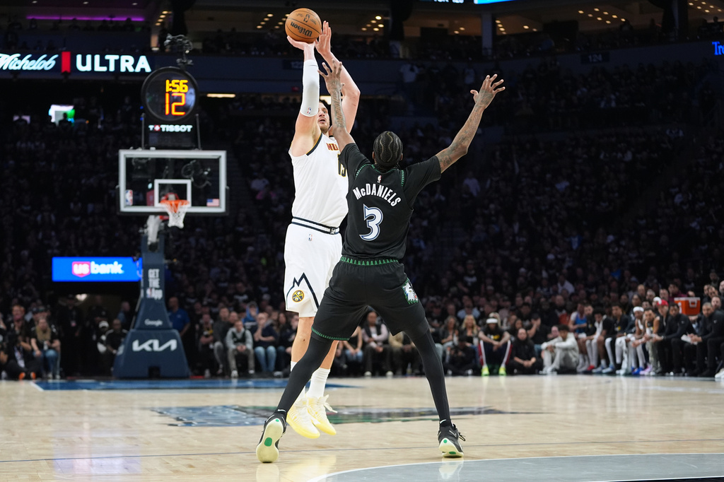 Denver Nuggets center Nikola Jokic (15) shoots over Minnesota Timberwolves forward Jaden McDaniels (3) during the first half in Game 3 of a first-round NBA basketball playoff series, Thursday, April 23, 2026, in Minneapolis. (AP Photo/Abbie Parr)