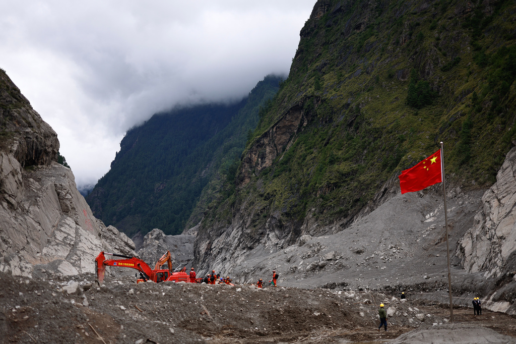 Rescue workers conduct search and rescue operations, near a Chinese national flag, at the core disaster-hit area at Gyirong Port amid rescue efforts following the August 26 mudslide, during an organised media tour in Shigatse, Tibet Autonomous Region, China, Sunday, Sept. 6, 2026. (Tingshu Wang/Pool Photo via AP)