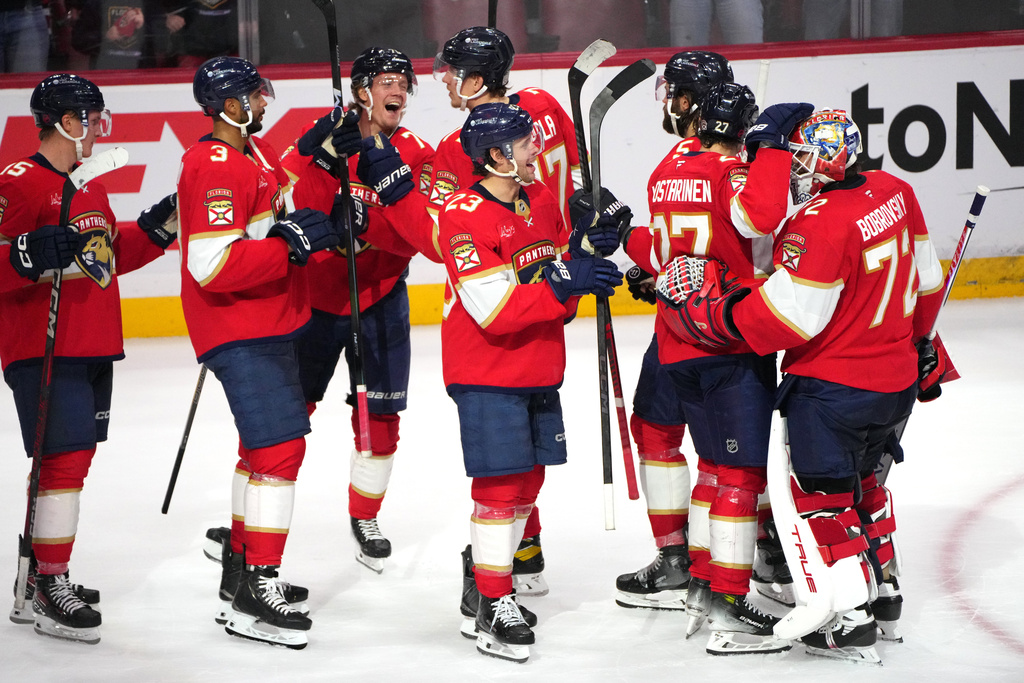 Florida Panthers goaltender Sergei Bobrovsky (72) celebrates with teammates after an NHL hockey game overtime win against the Carolina Hurricanes, Friday, Dec. 19, 2025, in Sunrise, Fla. (AP Photo/Jim Rassol)