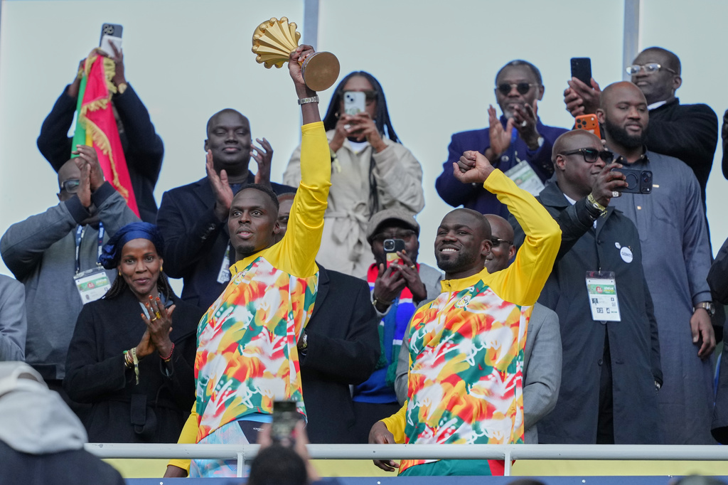 Senegal players celebrate with the Africa Cup of Nations trophy ahead of the international friendly soccer match between Senegal and Peru in Saint-Denis, outside of Paris, Saturday, March 28, 2026. (AP Photo/Aurelien Morissard)