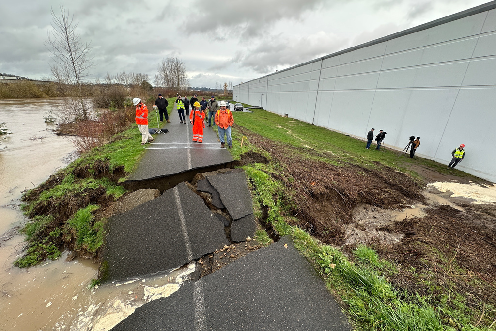 Crews inspect a crack in a levee along the Green River in Tukwila, Wash., Monday, Dec. 15, 2025. (AP Photo/Manuel Valdes)