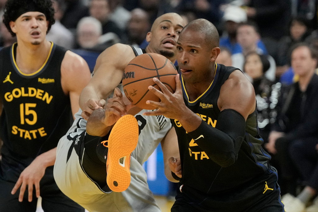Golden State Warriors center Al Horford, right, grabs a rebound against San Antonio Spurs guard Keldon Johnson during the first half of an NBA basketball game in San Francisco, Wednesday, Feb. 11, 2026. (AP Photo/Jeff Chiu)