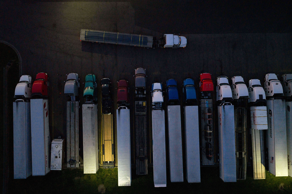 A tractor-trailer moves past parked trucks at a gas station on Tuesday, April 7, 2026, in Aurora, Ore. (AP Photo/Jenny Kane)