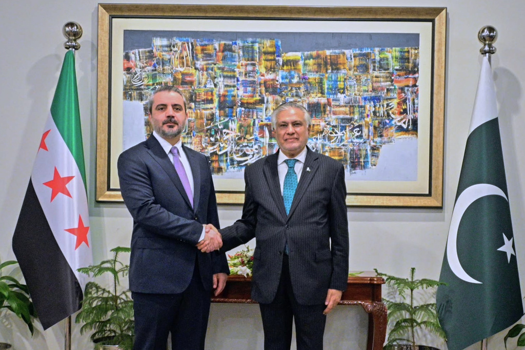 In this photo released by the Pakistan Ministry of Foreign Affairs, Syrian Foreign Minister Asaad Hassan al-Shibani, left, shakes hands with his Pakistani counterpart Ishaq Dar before their meeting in Islamabad, Pakistan, Thursday, Aug. 20, 2026. (Pakistan Ministry of Foreign Affairs via AP)