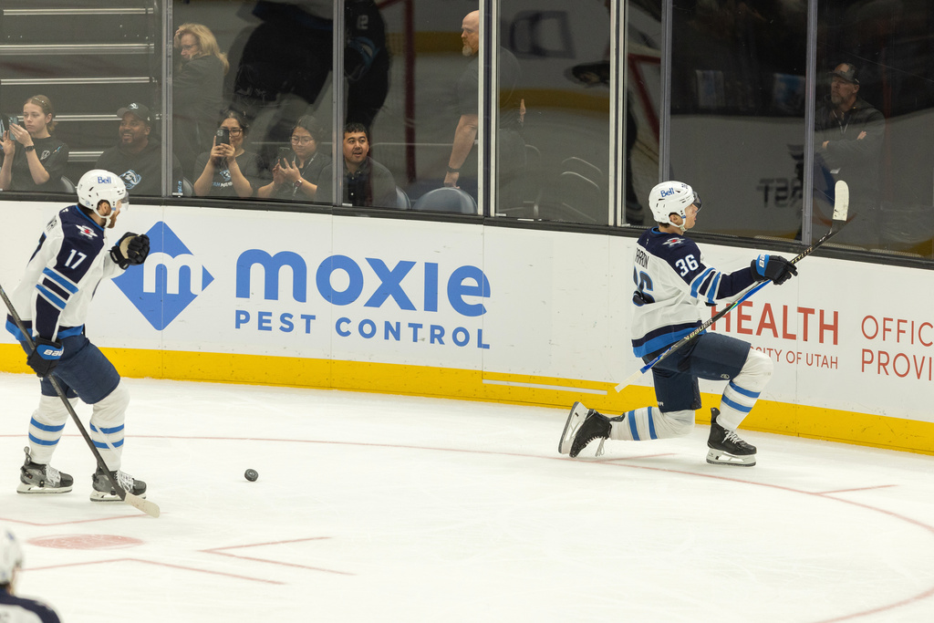 Winnipeg Jets center Morgan Barron (36) and Winnipeg Jets center Adam Lowry (17) celebrate the goal against the Utah Mammoth during the third period of an NHL hockey game, Sunday, Dec. 21, 2025, in Salt Lake City. (AP Photo/Melissa Majchrzak)