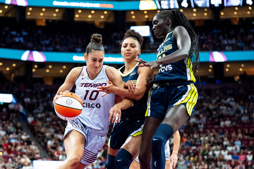 Toronto Tempo's Maria Conde (10) drives past Dallas Wings' Awak Kuier (34) and Azzi Fudd (35) during first half of a WNBA basketball game, in Montreal on Friday, July 10, 2026. (Christopher Katsarov/The Canadian Press via AP)