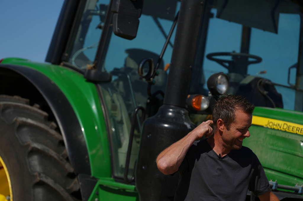 Farmer Maarten Janse stands next to his tractor on a drought stricken wheat field in Wolphaartsdijk, Netherlands, Tuesday, Aug. 11, 2026. (AP Photo/Virginia Mayo)