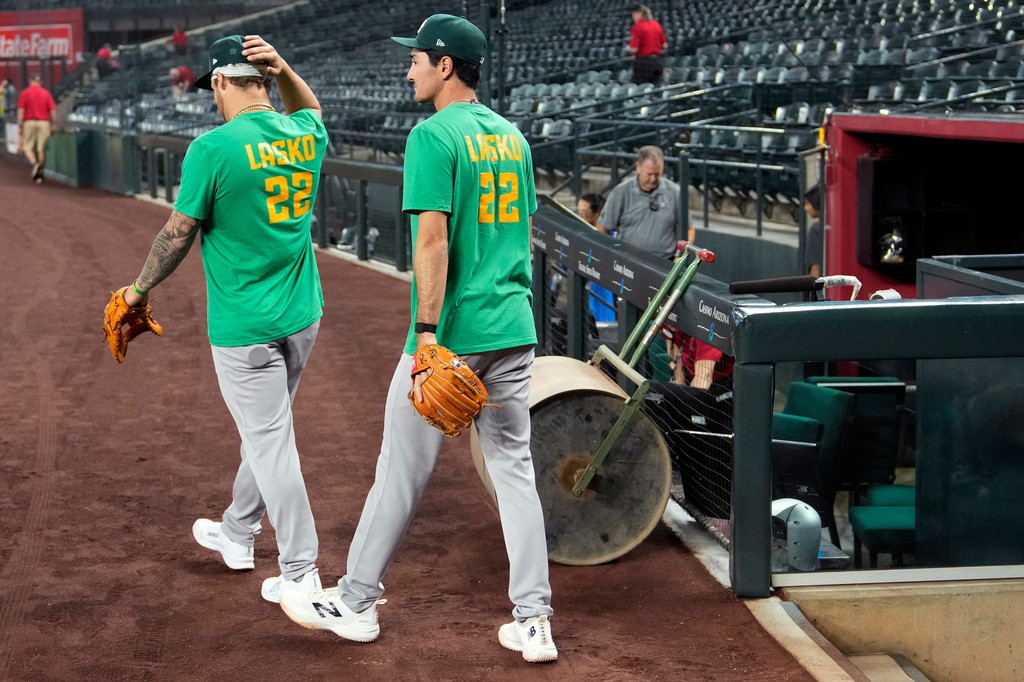 Athletics' Tommy White, left, and Alika Williams wear a Lasko No. 22 t-shirt in honor of injured Athletics minor league player Ryan Lasko prior to a baseball game against the Arizona Diamondbacks, Wednesday, July 22, 2026, in Phoenix. (AP Photo/Ross D. Franklin)