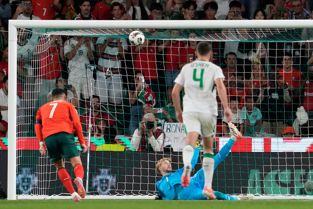 Caoimhin Kelleher goalkeeper of Ireland, bottom, saves a penalty kick from Portugal's Cristiano Ronaldo during a 2026 World Cup qualifying soccer match between Portugal and Ireland in Group F in Lisbon on Saturday, October 11, 2025. (AP Photo/Armando Franca)