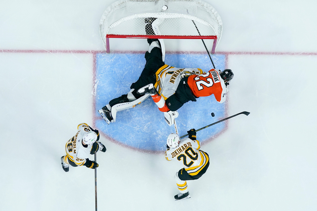 Boston Bruins' Jeremy Swayman, center left, makes a save on the shot attempt by Philadelphia Flyers' Christian Dvorak, right, during the second period of an NHL hockey game Saturday, Feb. 28, 2026, in Philadelphia. (AP Photo/Chris Szagola)