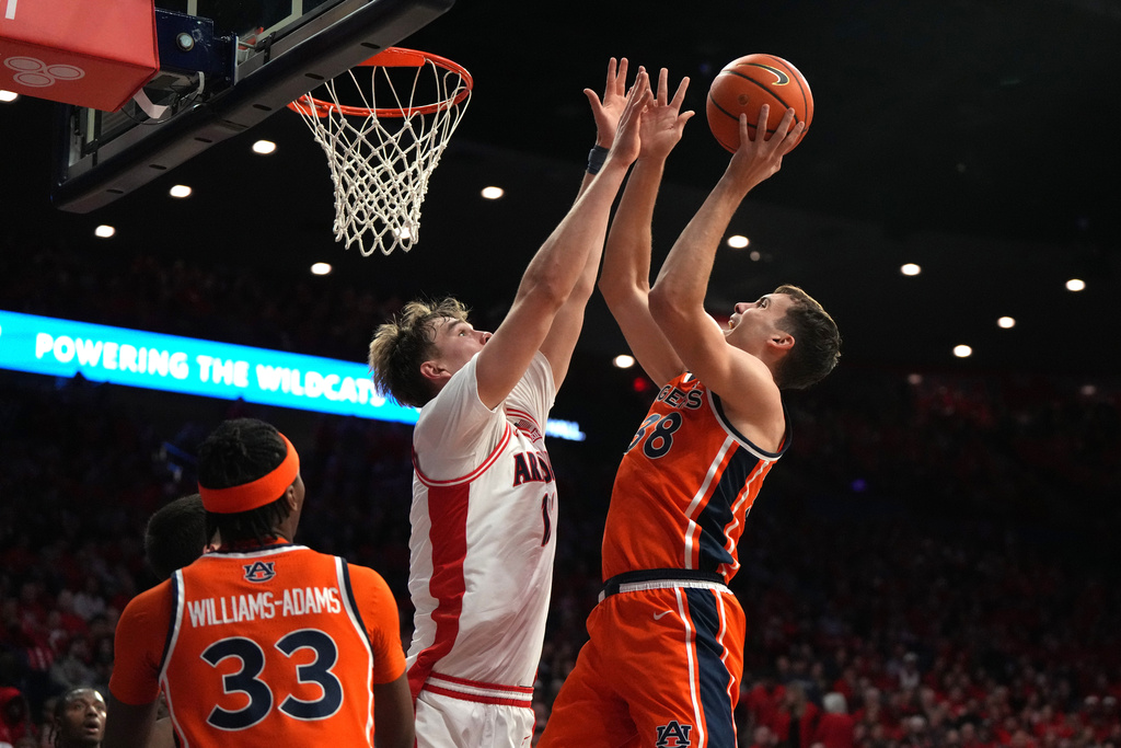 Auburn forward Filip Jovic, right, shoots on Arizona center Motiejus Krivas during the first half of an NCAA college basketball game, Saturday, Dec. 6, 2025, in Tucson, Ariz. (AP Photo/Rick Scuteri)