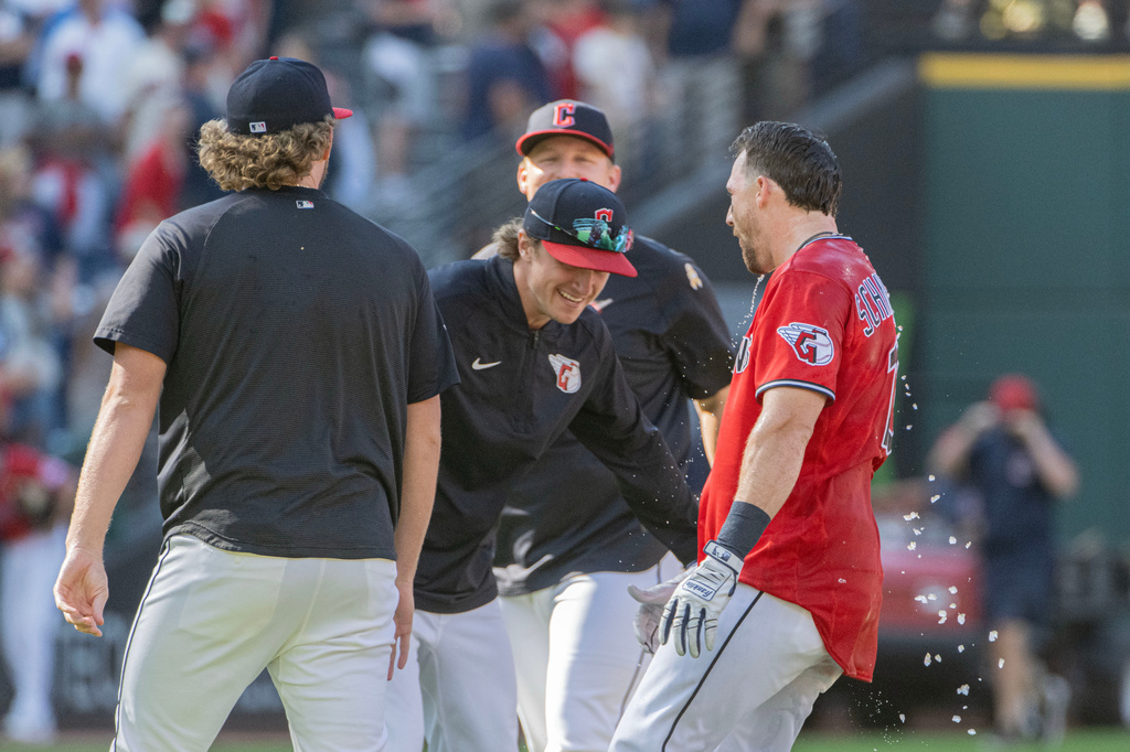 Cleveland Guardians' Daniel Schneemann, right, is greeted by Petey Halpin, center, and other teammates after hitting the winning single in the 10th inning of a baseball game against the Detroit Tigers, Sunday, Sept. 6, 2026, in Cleveland. (AP Photo/Phil Long)