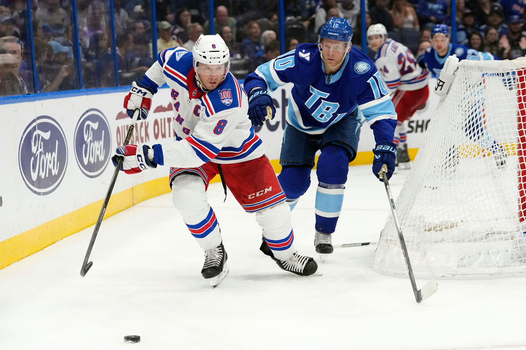 New York Rangers center J.T. Miller (8) and Tampa Bay Lightning right wing Corey Perry (10) chase a loose puck during the third period of an NHL hockey game Wednesday, April 15, 2026, in Tampa, Fla. (AP Photo/Chris O'Meara)