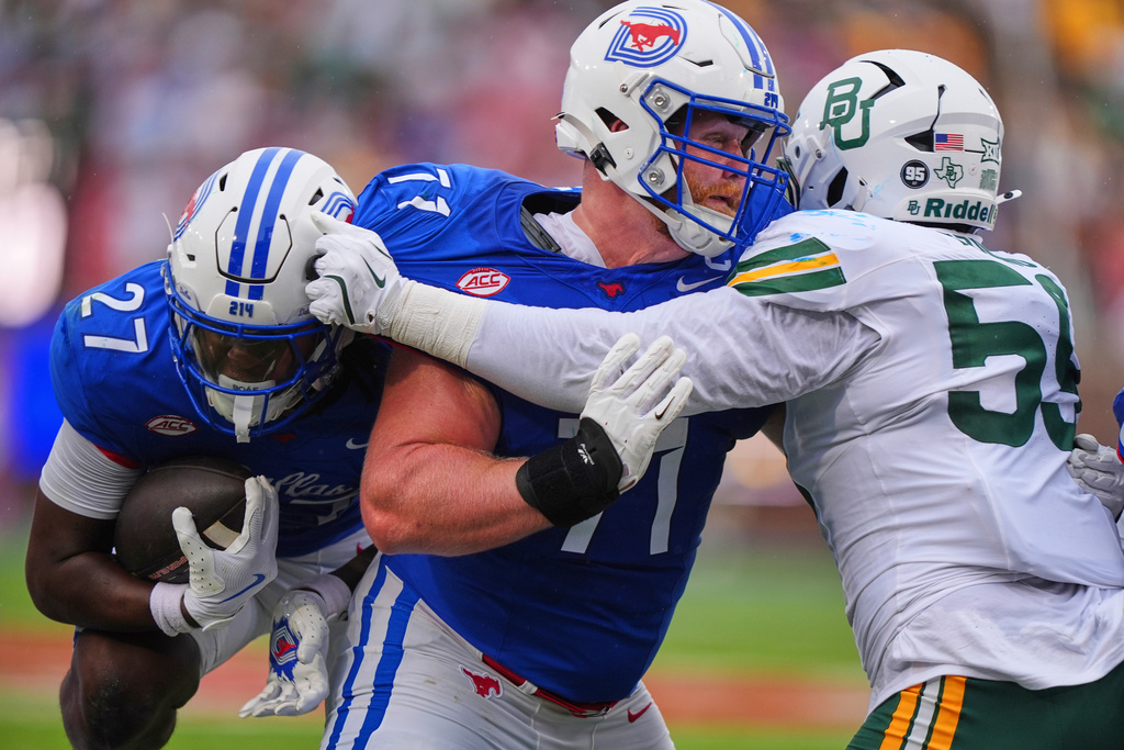 SMU running back T.J. Harden (27), on his way to scoring a touchdown, gets a block from offensive lineman Alex Woods (77) against Baylor defensive lineman Devonte Tezino (59) during the first half of an NCAA college football game Saturday, Sept. 6, 2025, in Dallas. (AP Photo/LM Otero)