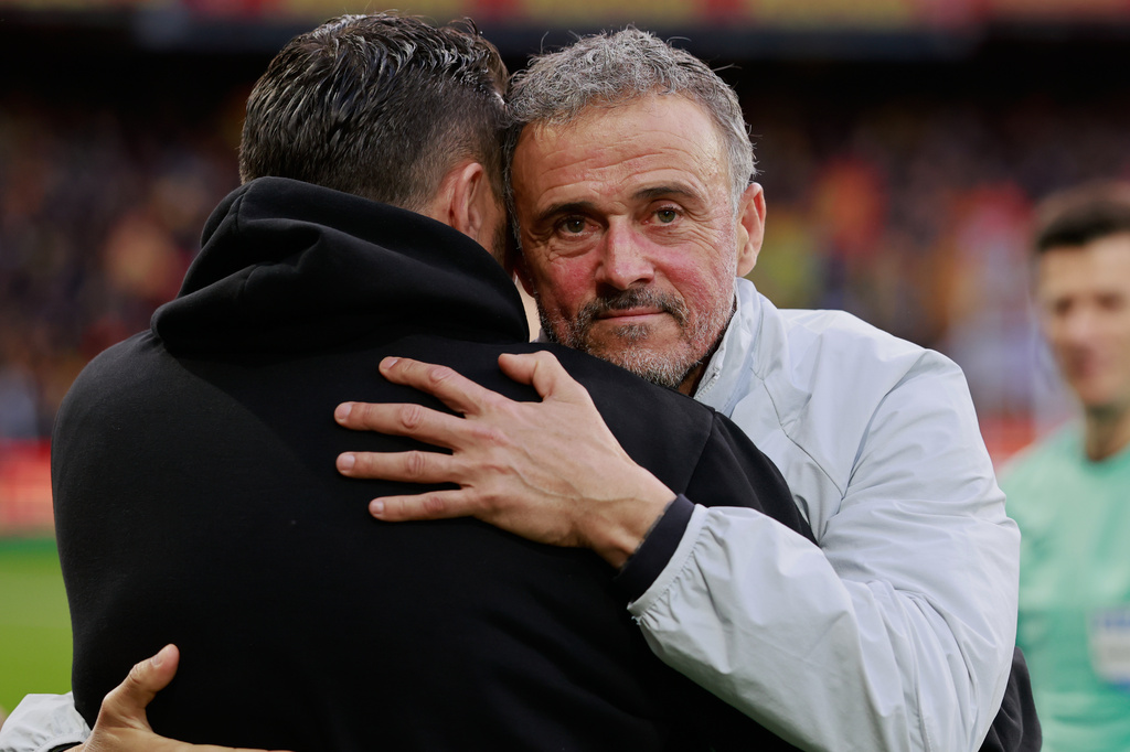 PSG's head coach Luis Enrique, right, hugs Lens' head coach Pierre Sage prior to the start of the French League One soccer match between Lens and Paris Saint Germain, in Lens, northern France, Wednesday, May 13, 2026. (AP Photo/Jean-Francois Badias)