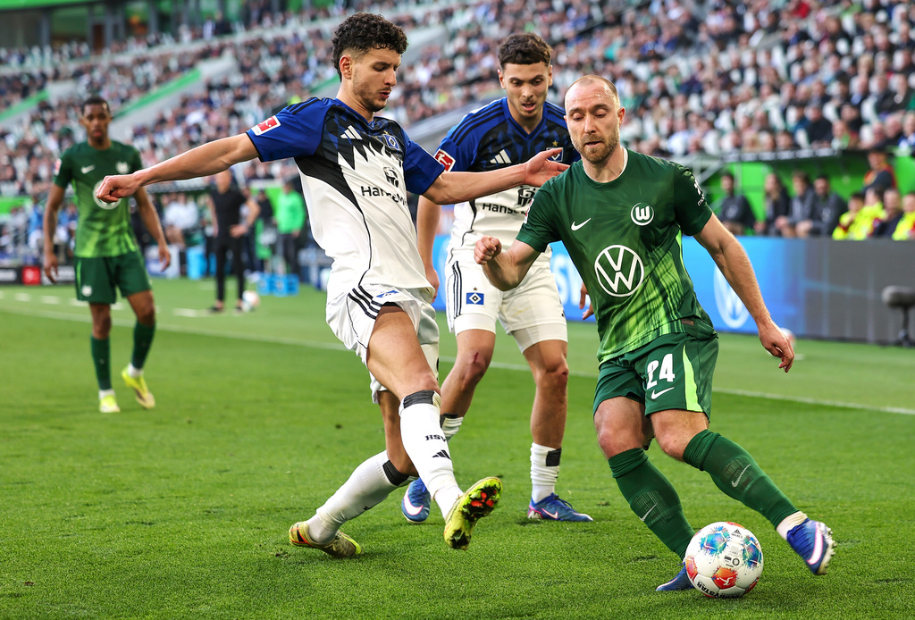 Wolfsburg's Christian Eriksen, right, and Hamburger's Daniel Elfadli battle for the ball during their German Bundesliga soccer match in Wolfsburg, Germany, Saturday, March 7, 2026. (Andreas Gora/dpa via AP)