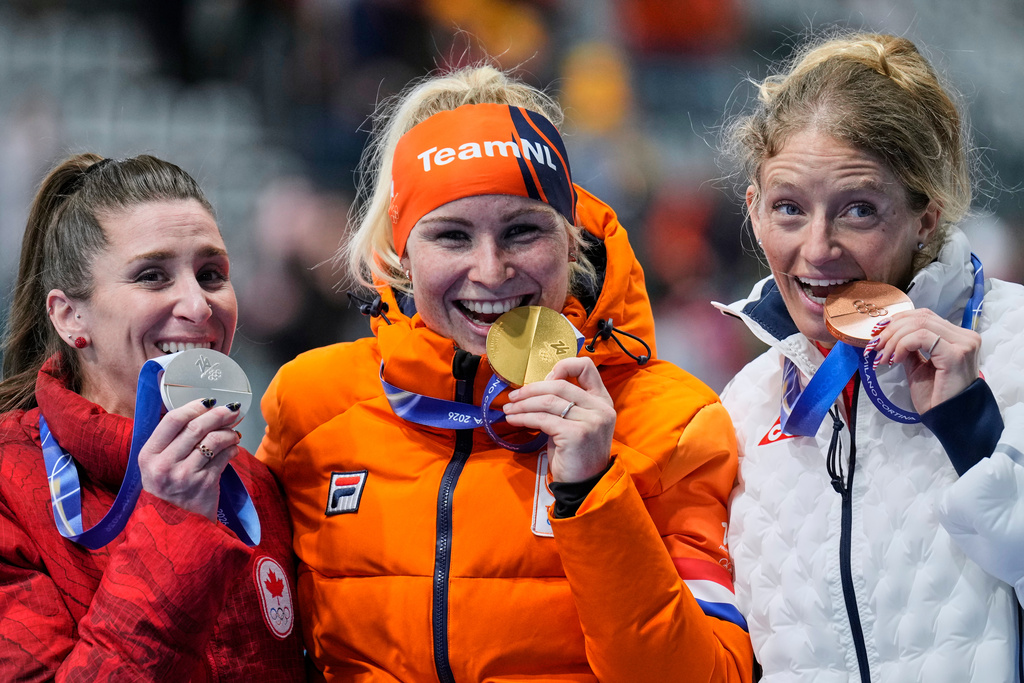 Marijke Groenewoud of the Netherlands, center and gold medal, Ivanie Blondin of Canada, left and silver medal, and Mia Manganello of the U.S., right and bronze medal, celebrate on the podium of the mass start speedskating race at the 2026 Winter Olympics, in Milan, Italy, Saturday, Feb. 21, 2026. (AP Photo/Luca Bruno)