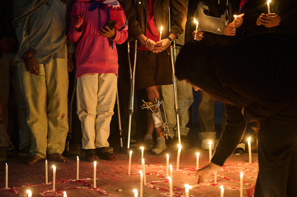 Members of Gen Z protest groups are joined by injured victims and family members of those who died during September protests at a candlelight vigil outside the Parliament building in Kathmandu, Nepal, on Dec. 9, 2025. (AP Photo/Niranjan Shrestha)