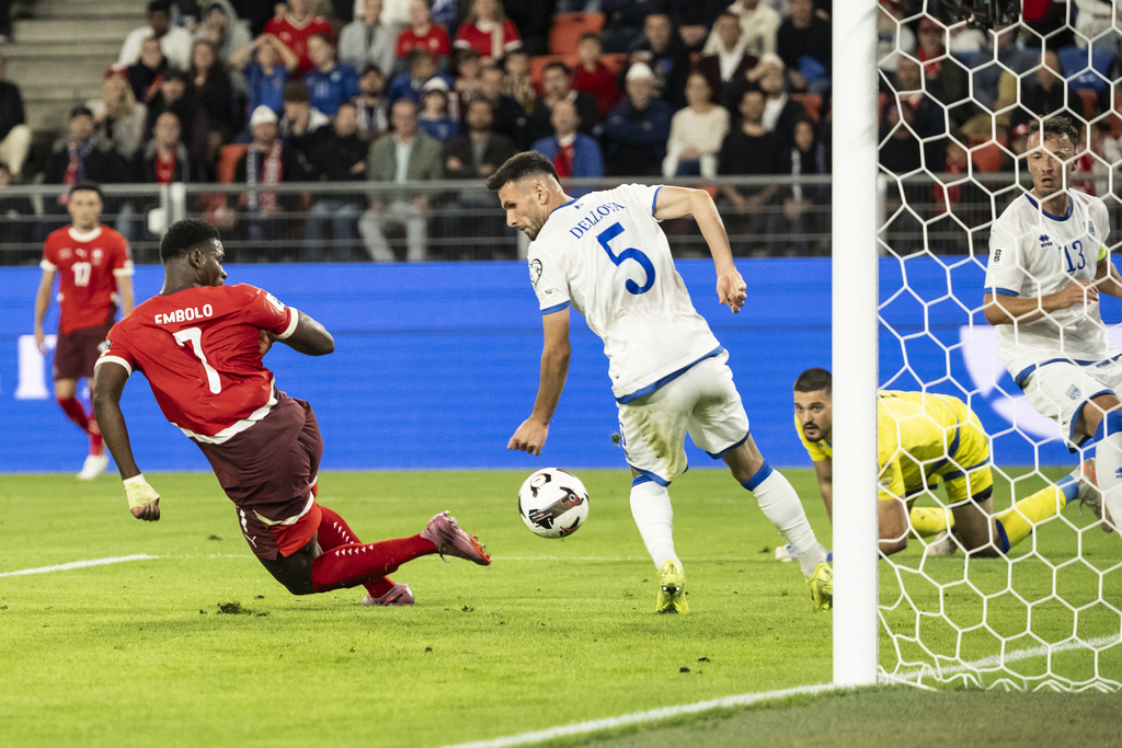 Switzerland's Breel Embolo, left, scores his side's 4:0 against Kosovo's Lumbardh Dellova, goalkeeper Arijanet Muric and Amir Rrahmani, from left, during the 2026 World Cup Group B qualifying soccer match between Switzerland and Kosovo at the St. Jakob-Park stadium in Basel, Switzerland, on Friday, Sept. 5, 2025. (Georgios Kefalas/Keystone via AP)