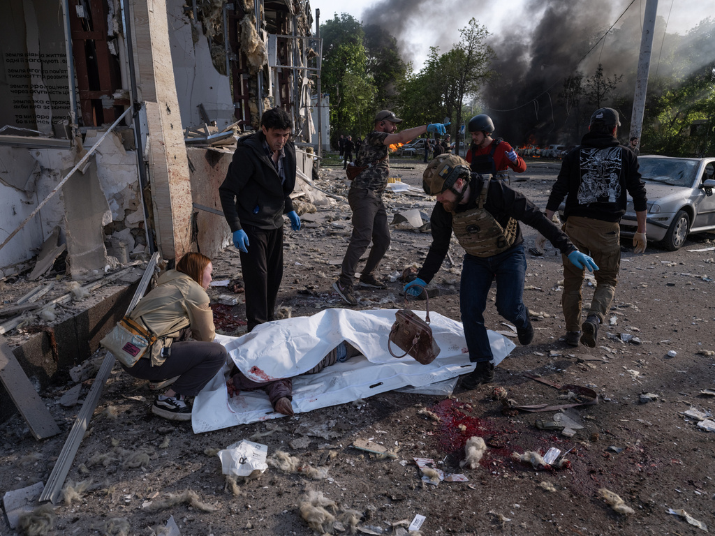 In this photo provided by Ukraine's 93rd Kholodnyi Yar Separate Mechanized Brigade press service, people cover bodies of civilians killed in Russia's aerial guided bomb attack in Kramatorsk, Donetsk region, Ukraine, Tuesday, May 5, 2026. (Iryna Rybakova/Ukraine's 93rd Mechanized Brigade via AP)