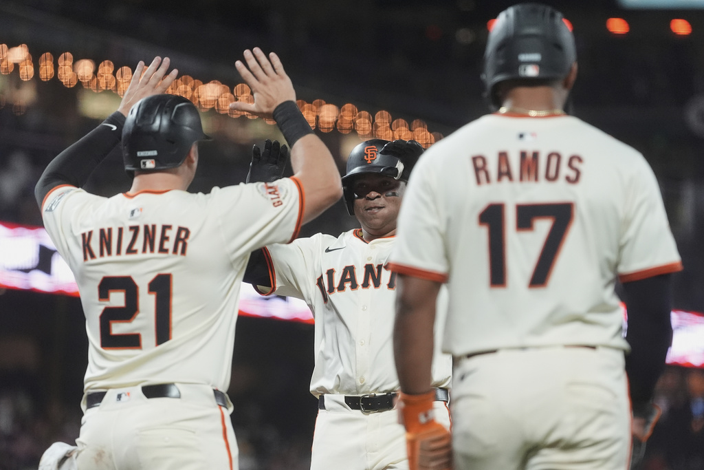 San Francisco Giants' Rafael Devers, middle, celebrates after hitting a three-run home run that also scored Andrew Knizner (21) and Heliot Ramos (17) during the sixth inning of a baseball game against the Chicago Cubs in San Francisco, Wednesday, Aug. 27, 2025. (AP Photo/Jeff Chiu)