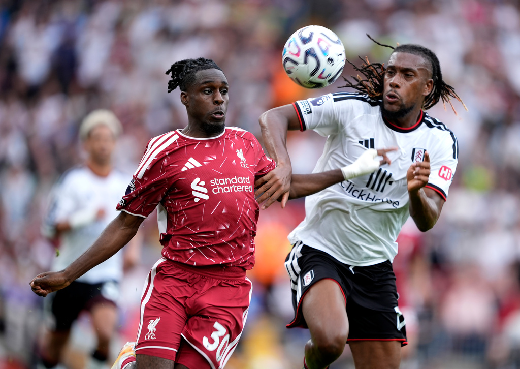 Liverpool's Jeremie Frimpong, left, and Fulham's Alex Iwobi battle for the ball during the English Premier League soccer match between Liverpool and Fulham in Liverpool, England, Saturday Sept. 12, 2026. (Peter Byrne/PA via AP)