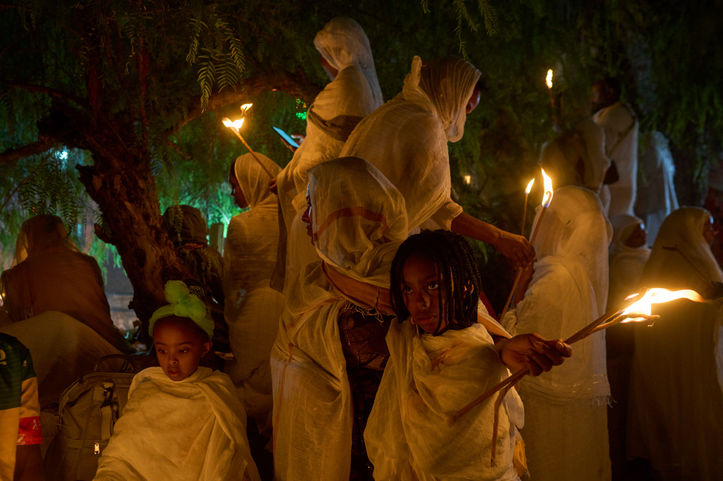 Ethiopian Orthodox Christian worshippers hold candles on the eve of the Meskel holiday at the Ethiopian monks' village, Deir Al‑Sultan, located on the rooftop of the Church of the Holy Sepulcher in Jerusalem's Old City, Saturday, Sept. 26, 2026. (AP Photo/Ohad Zwigenberg)