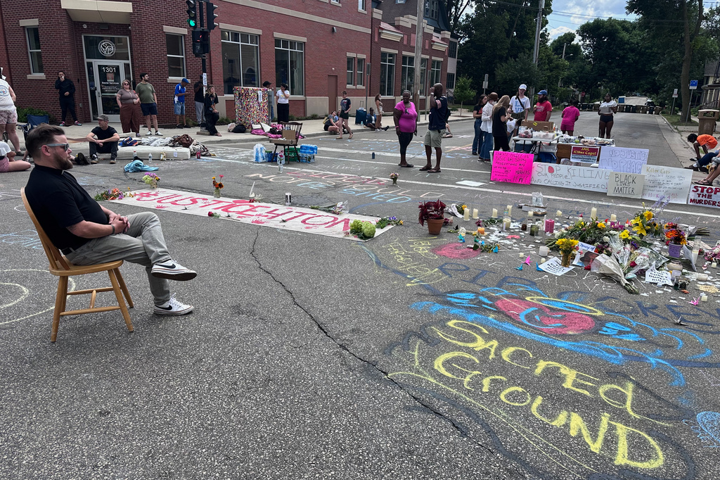 Mourners gather around a memorial at the site where a man was shot and killed on Wednesday by Madison police, Thursday, July 23, 2026, in Madison, Wis. (AP Photo/Scott Bauer)