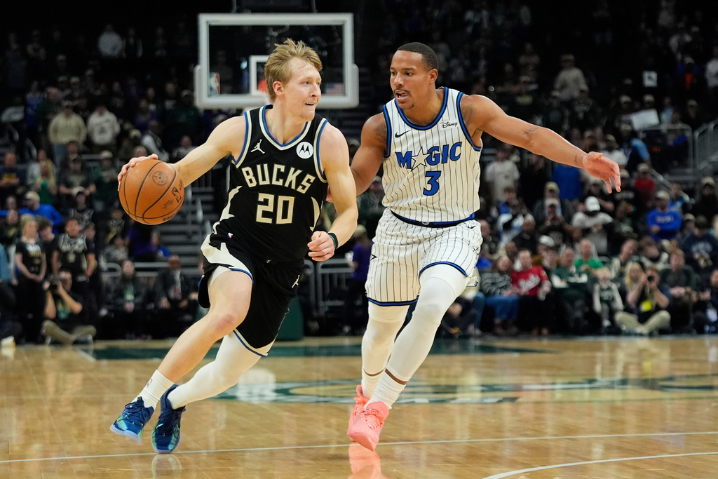Milwaukee Bucks' AJ Green (20) drives to the basket against Orlando Magic's Desmond Bane during the first half of an NBA basketball game, Sunday, March 8, 2026, in Milwaukee. (AP Photo/Aaron Gash)