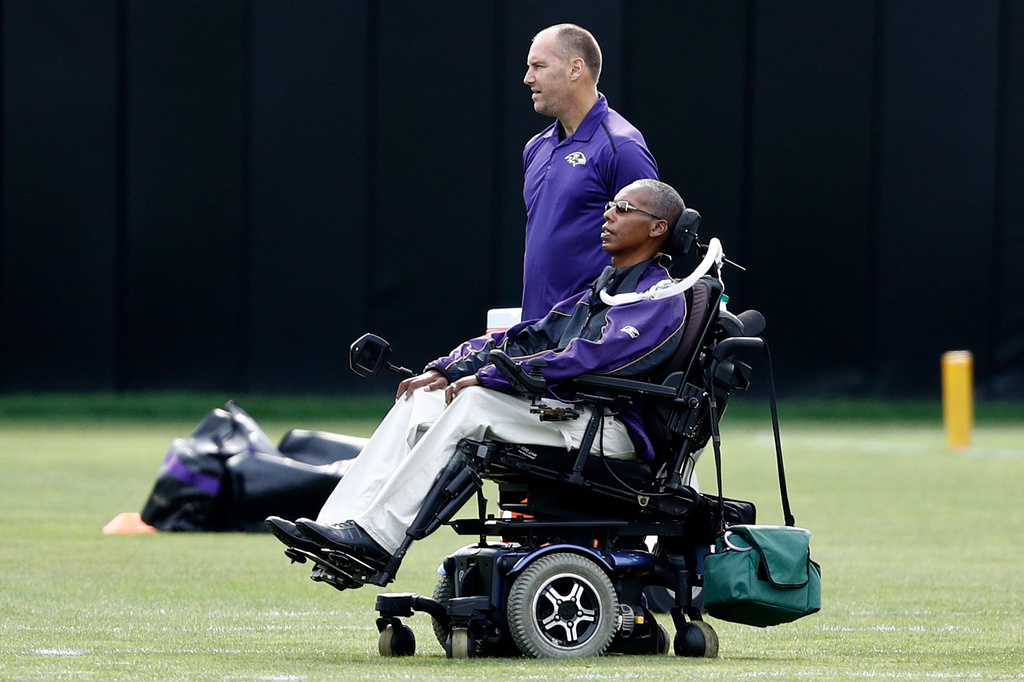 FILE - Baltimore Ravens senior advisor to player engagement O.J. Brigance, bottom, watches an NFL football training camp practice in Owings Mills, Md., Aug. 8, 2017. (AP Photo/Patrick Semansky, File)