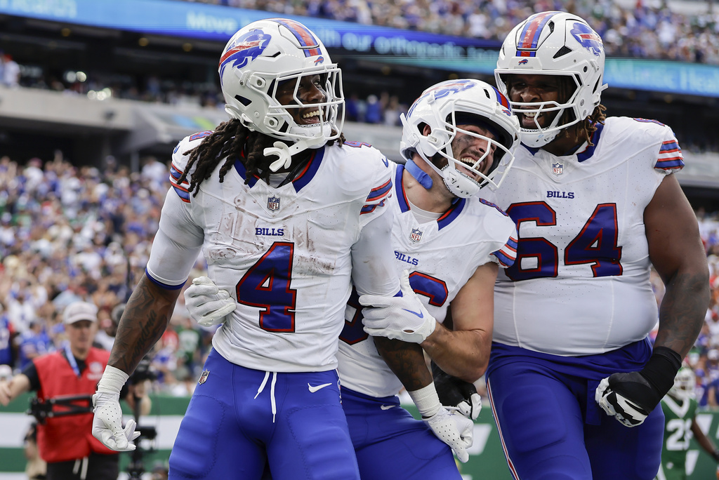 Buffalo Bills running back James Cook (4) celebrates with tight end Dalton Kincaid (86) and guard O'Cyrus Torrence (64) after scoring a touchdown against the New York Jets during the second quarter of an NFL football game, Sunday, Sept. 14, 2025, in East Rutherford, N.J. (AP Photo/Adam Hunger)