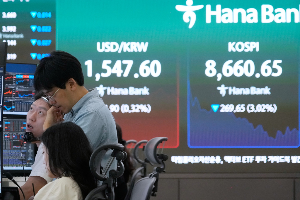 Currency traders work near a screen showing the Korea Composite Stock Price Index (KOSPI) and the foreign exchange rate between U.S. dollar and South Korean won at the foreign exchange dealing room of the Hana Bank headquarters in Seoul, South Korea, Friday, June 26, 2026. (AP Photo/Ahn Young-joon)