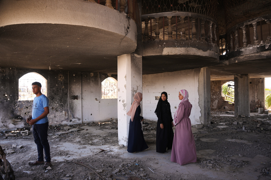 Fady al-Gharam, left, and his sisters inspect their family's home which was damaged during the Israel-Hamas war, in Nuseirat, central Gaza Strip, Thursday, June 4, 2026, while they are in the process of obtaining Israeli passports. (AP Photo)
