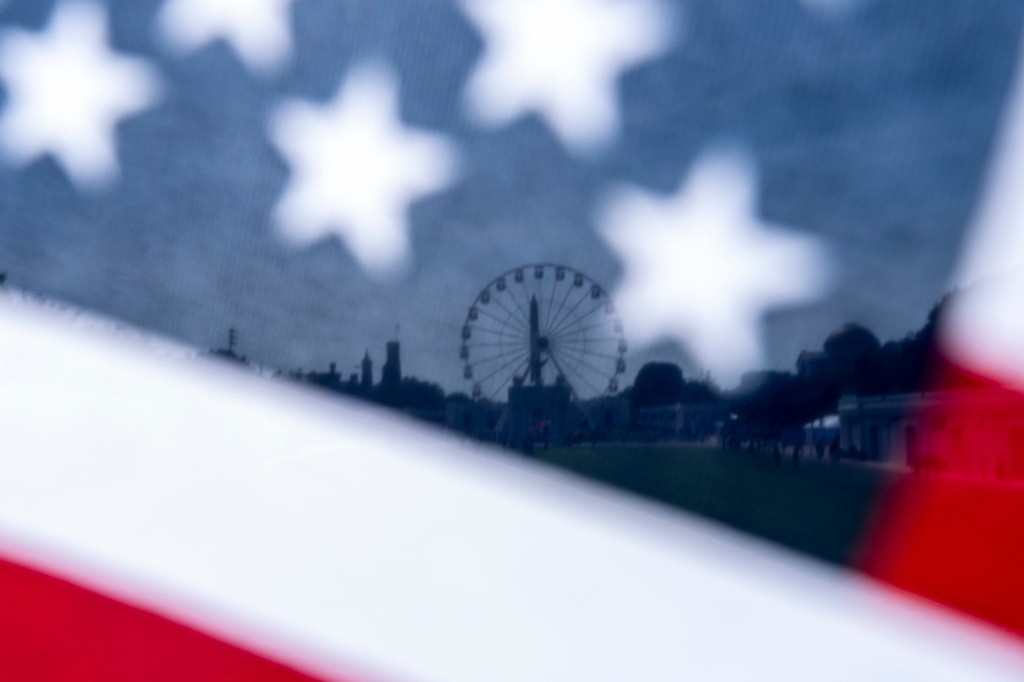 The Great American State Fair on the National Mall is seen through an American flag, Tuesday, June 30, 2026, in Washington. (AP Photo/Jen Golbeck)