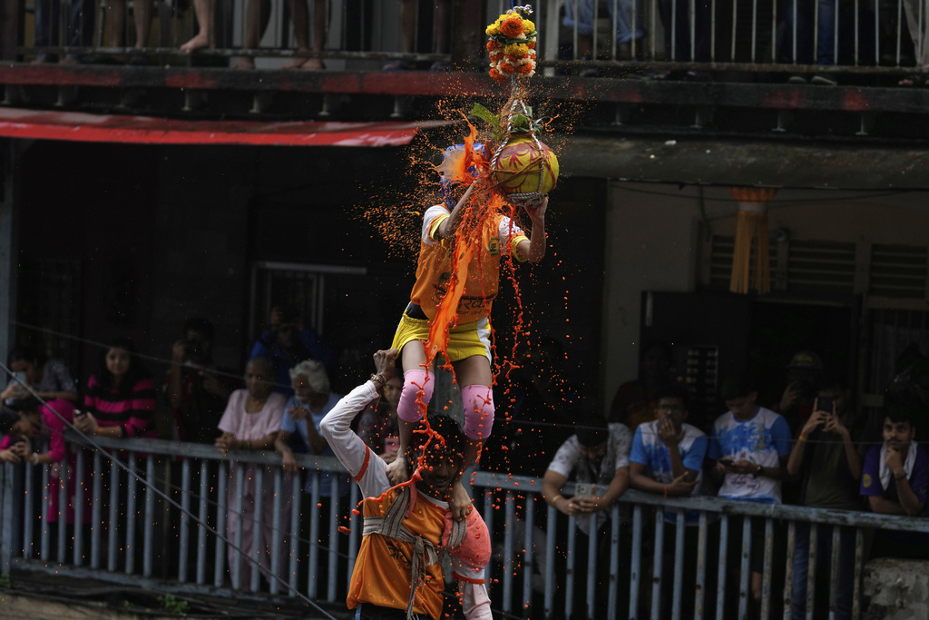 Curd spills as Indian devotees form a human pyramid and break an earthen pot filled with curd, as part of celebrations to mark Janmashtami festival in Mumbai, India, Saturday, Aug. 16, 2025. (AP Photo/Rajanish Kakade)